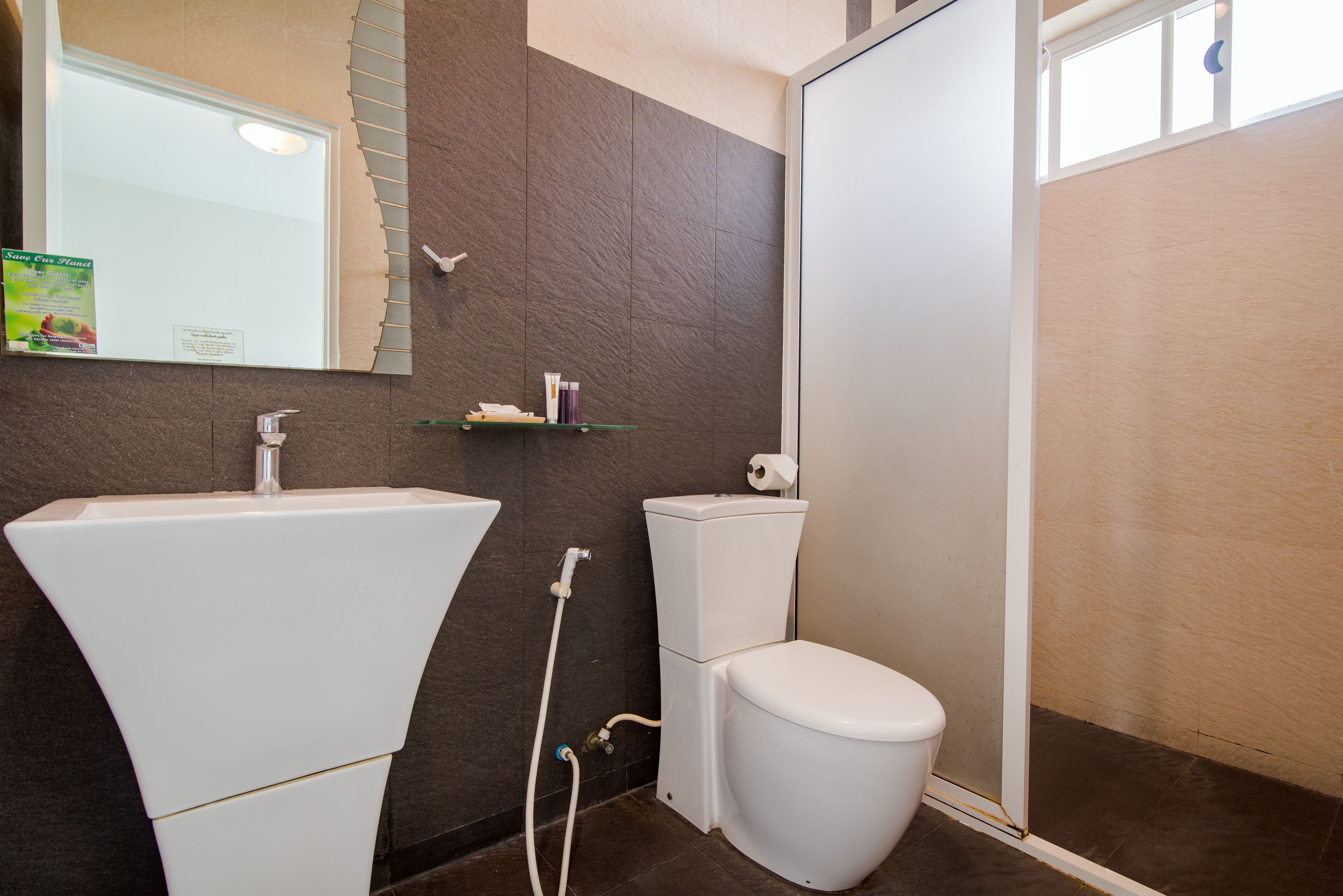 Un baño con lavamanos blanco, inodoro y zona de ducha.