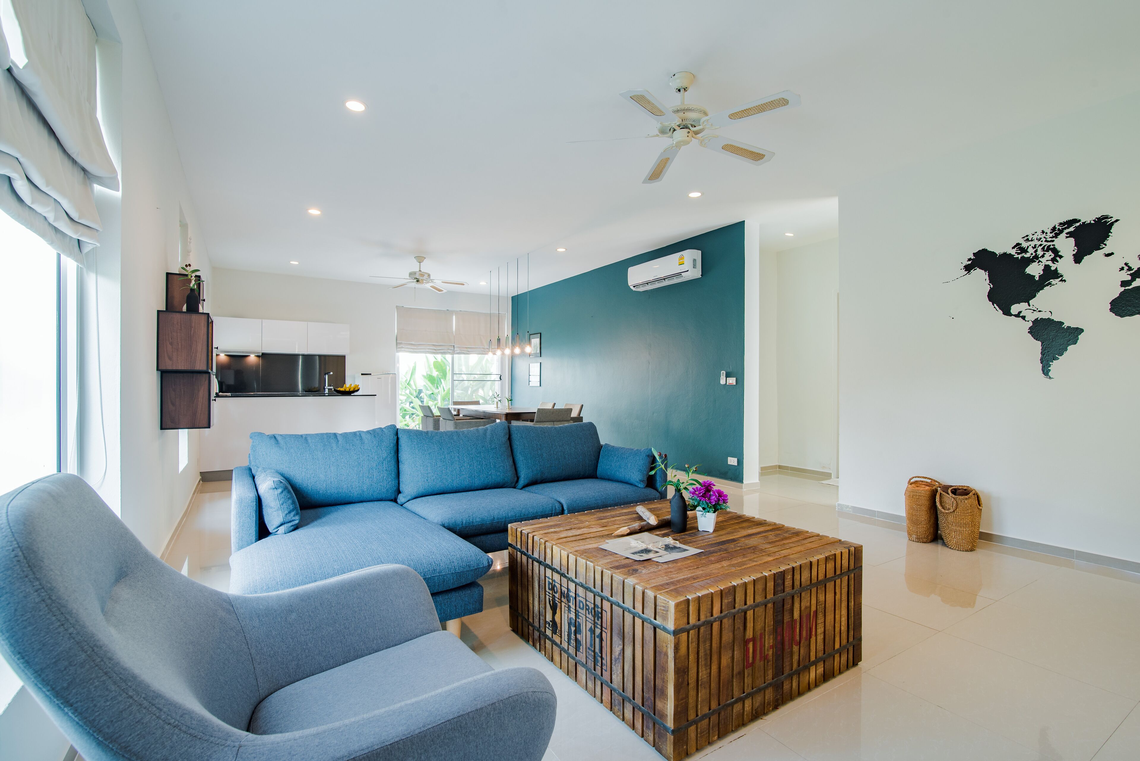 A modern living room with a sectional sofa, a wooden coffee table, and a world map on the wall.