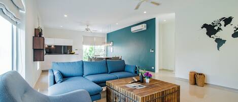 A modern living room with a sectional sofa, a wooden coffee table, and a world map on the wall.