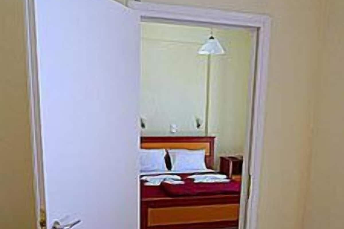 A room with a bed, a bedside table, and a lamp.