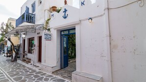Un edificio blanco con una puerta azul y un cartel que dice 'HOTEL CAPTAIN MANDLIS'.
