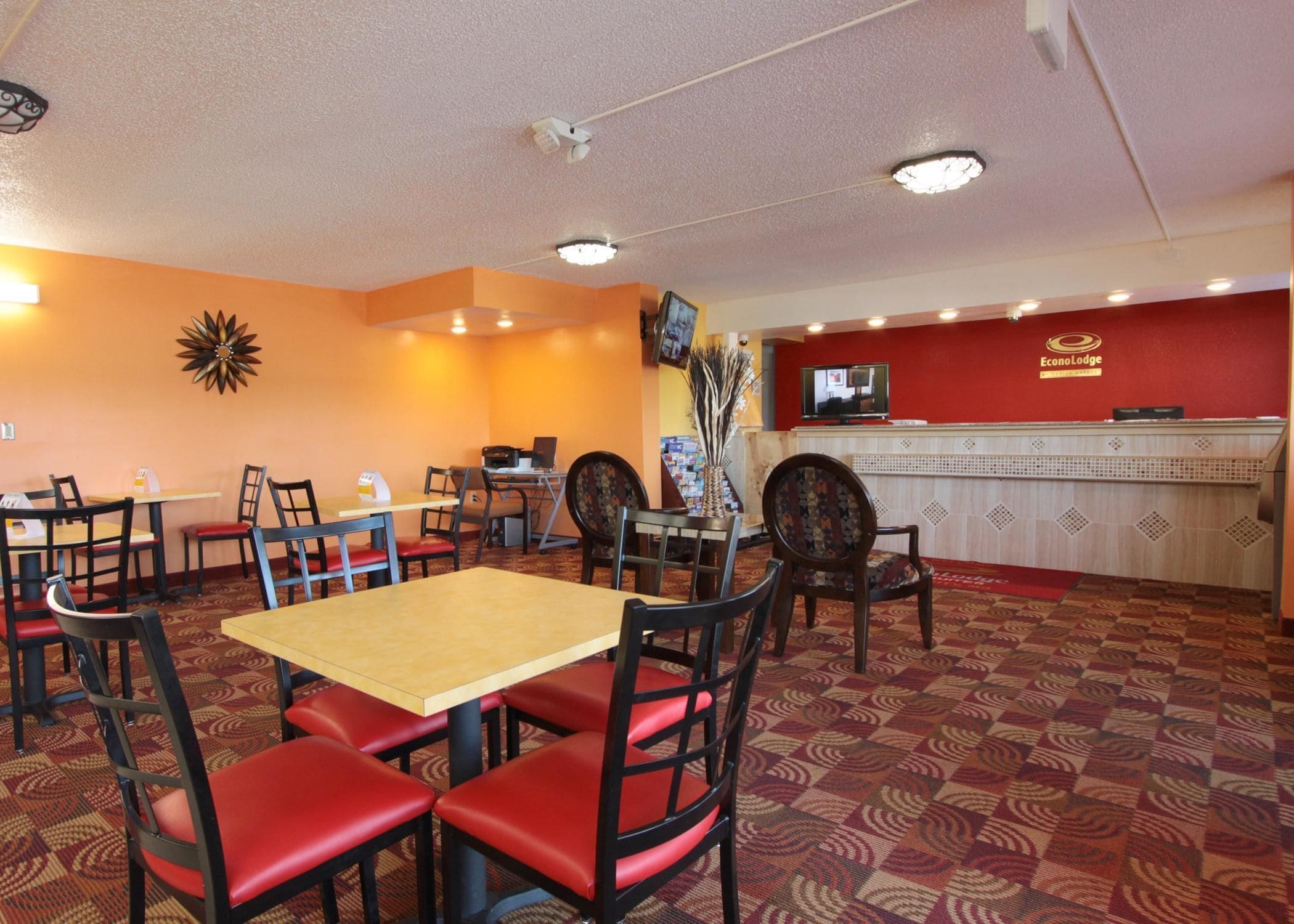 Un restaurante con mostrador de recepción, mesas y sillas.