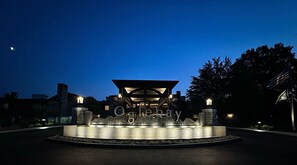 A well-lit entrance with a modern architectural design, featuring a central pavilion and a landscaped area with a water feature. - Oglebay Resort (Wheeling)