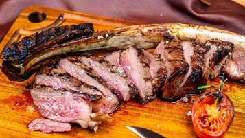 Een steak met een aangebrande korst op een houten snijplank.