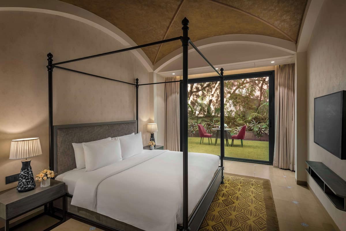 Una cama con dosel y cortina, un televisor en la pared y vistas al exterior.