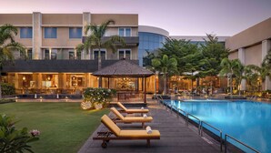 A poolside area with lounge chairs, a gazebo, and a bar area.