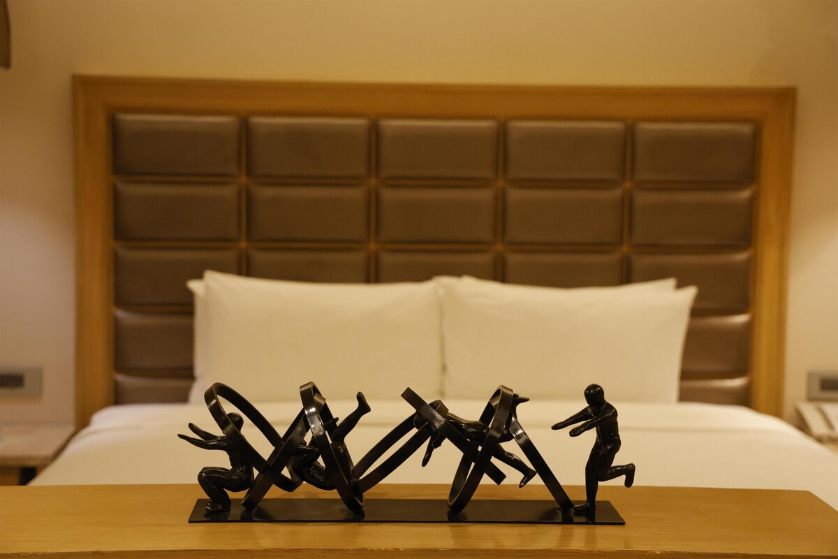 Un letto con testiera in una camera d'albergo.