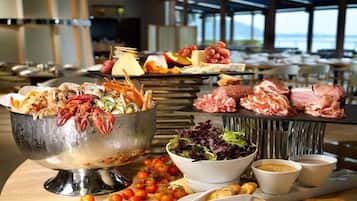 A buffet with seafood, meats, cheeses, and salads.