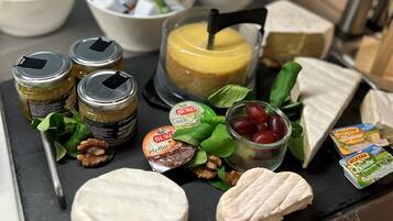 A variety of cheeses, nuts, and fruits on a serving board.