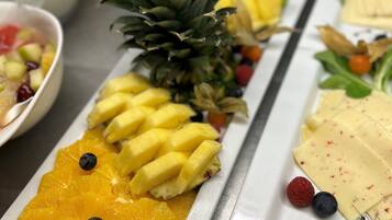 Un bufé de desayuno con diversas frutas y quesos.