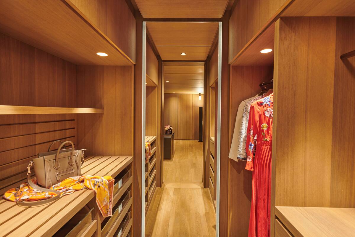 A wooden interior with a bench, a handbag, and a red garment on display.