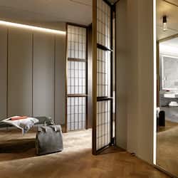 Sliding shoji screen door leads to a bathroom with a bench and amenities.