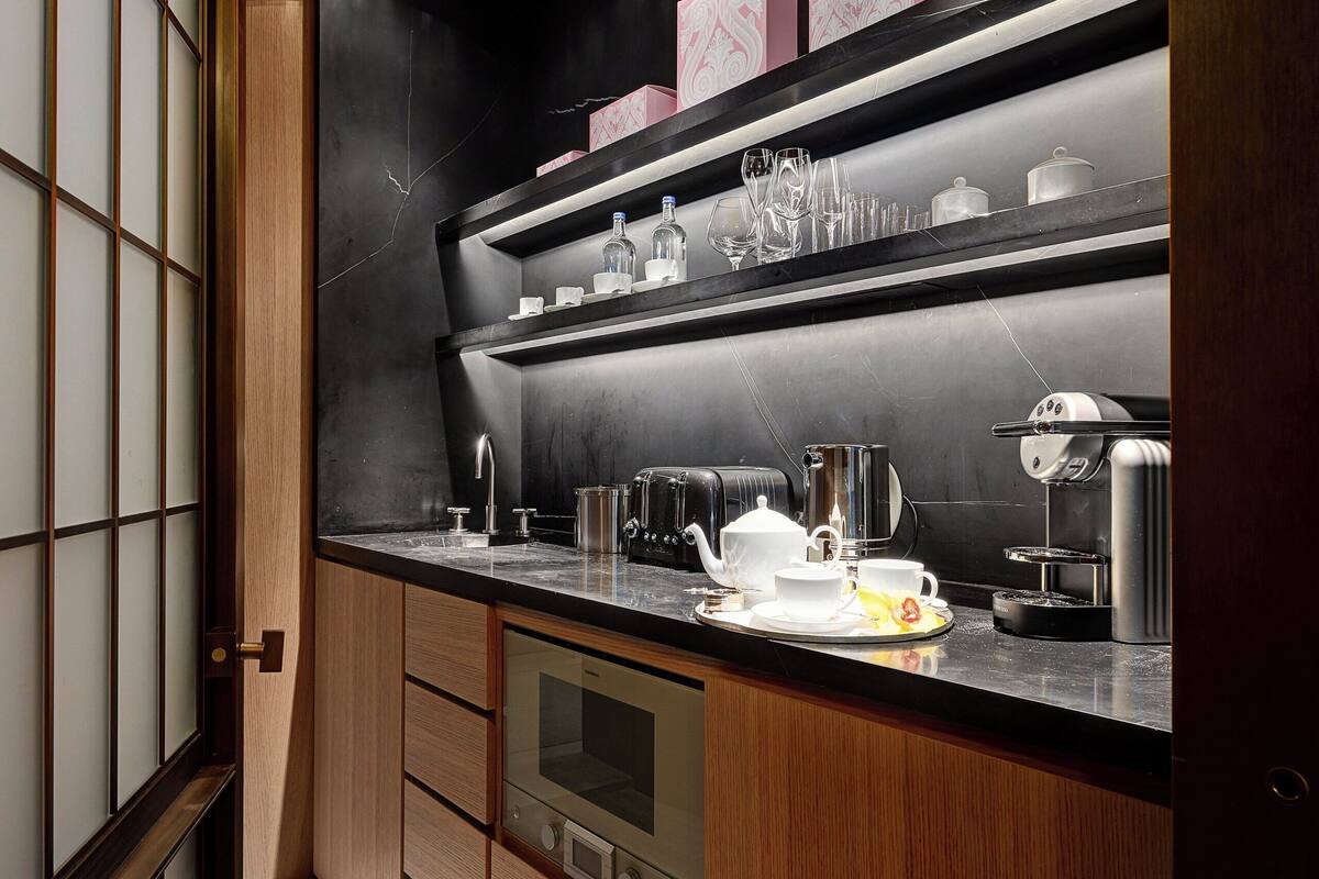 A modern kitchen with wooden cabinets, a black countertop, and stainless steel appliances.