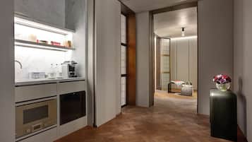 A modern kitchen with built-in appliances, a herringbone wood floor, and a minimalist design.