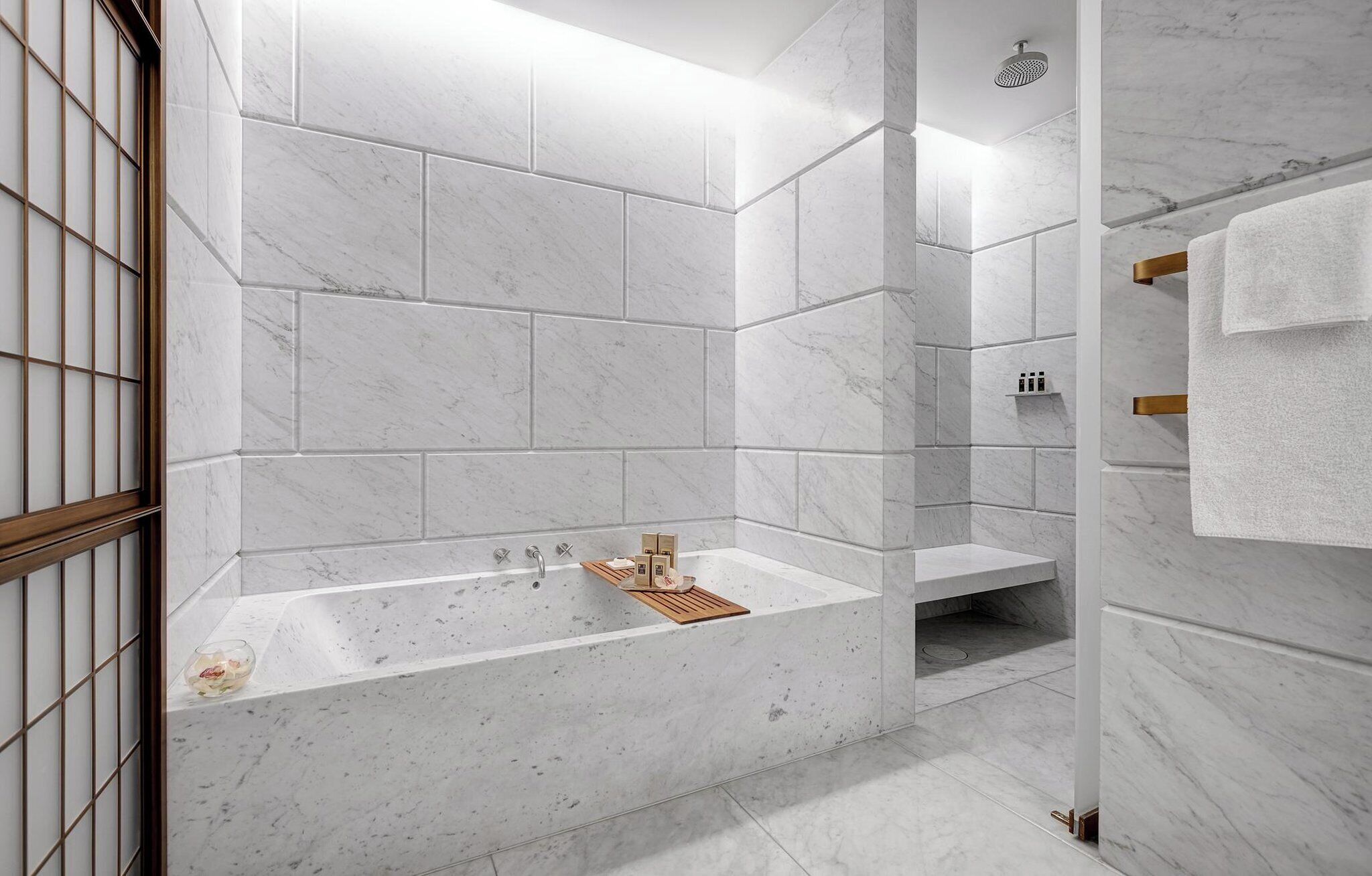 Een moderne badkamer met een vrijstaand bad, een douchegedeelte en een wastafel met een handdoekhouder.