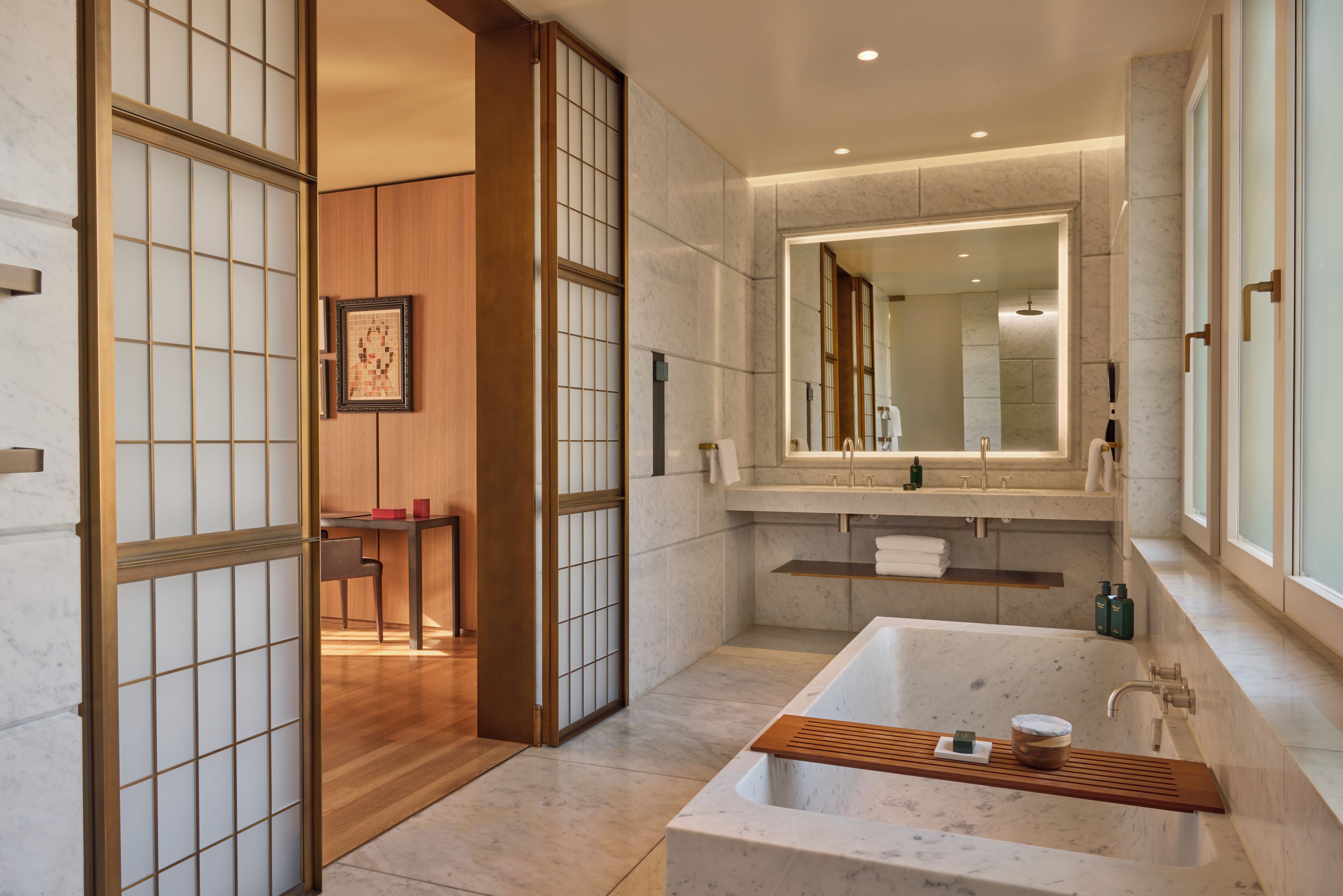Une salle de bain moderne avec une grande baignoire, un meuble-lavabo en bois et un grand miroir.