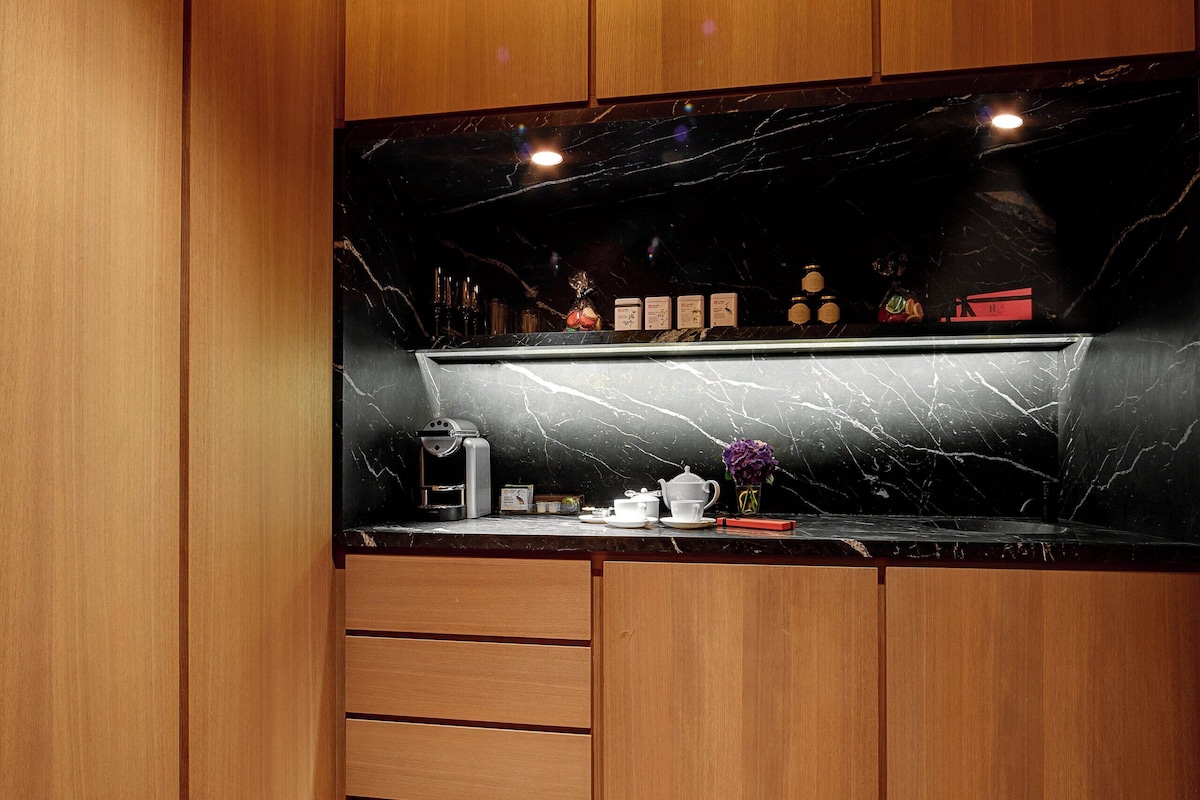 A kitchen with wooden cabinets, a marble countertop, and a built-in oven.