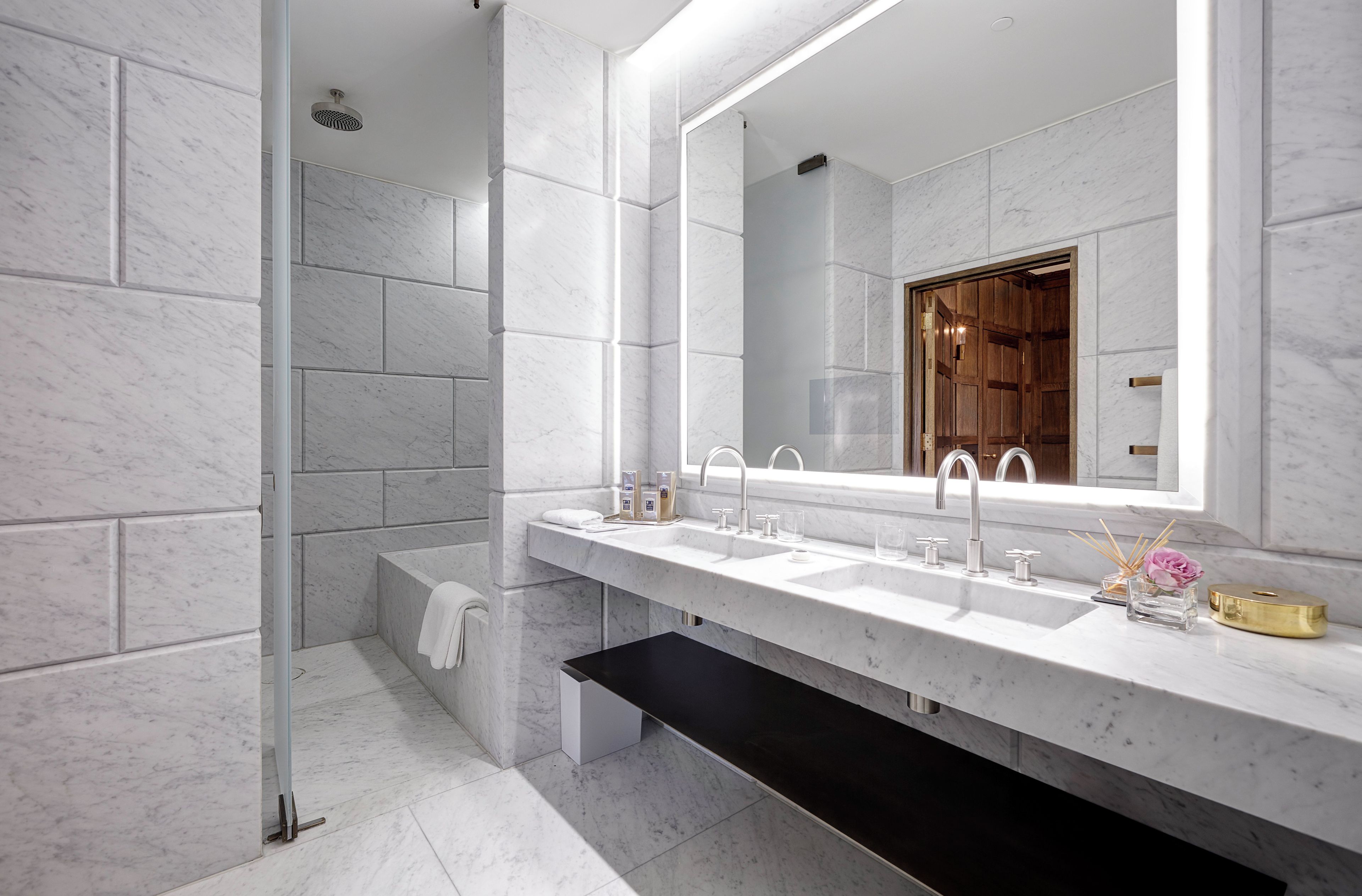 Un baño moderno con un espejo grande, dos lavabos y una zona de ducha.