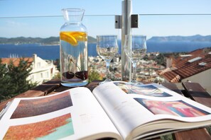 Una mesa con una revista, una botella de vidrio con una rodaja de limón y dos copas de vino.