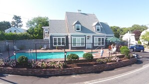 A two-story house with a swimming pool, a fenced backyard, and a street view. - Cutty Sark Motor Lodge (Dennis Port)