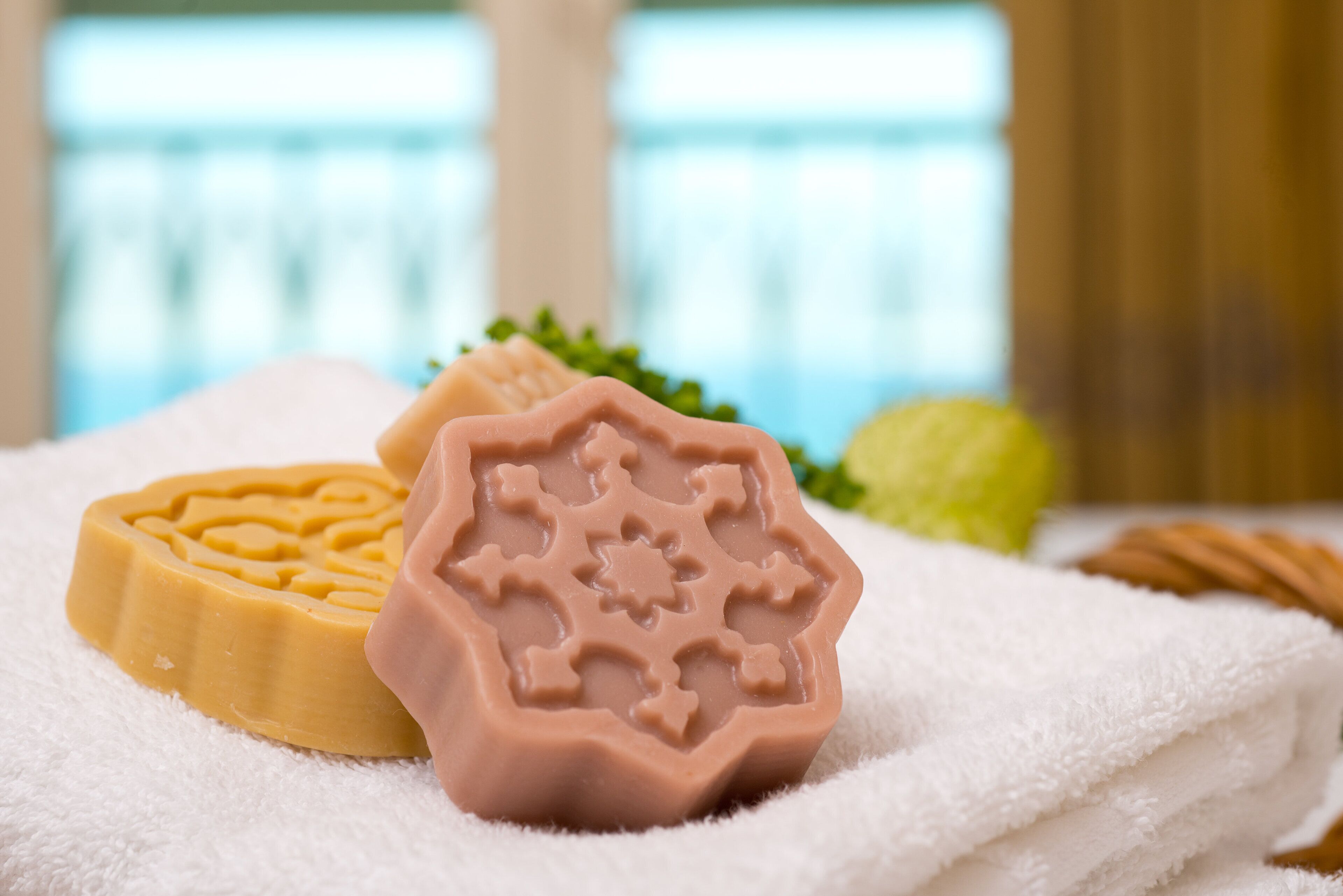 Three soap bars on a white towel.