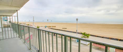 Une terrasse en bois avec des rampes en métal donnant sur une plage.