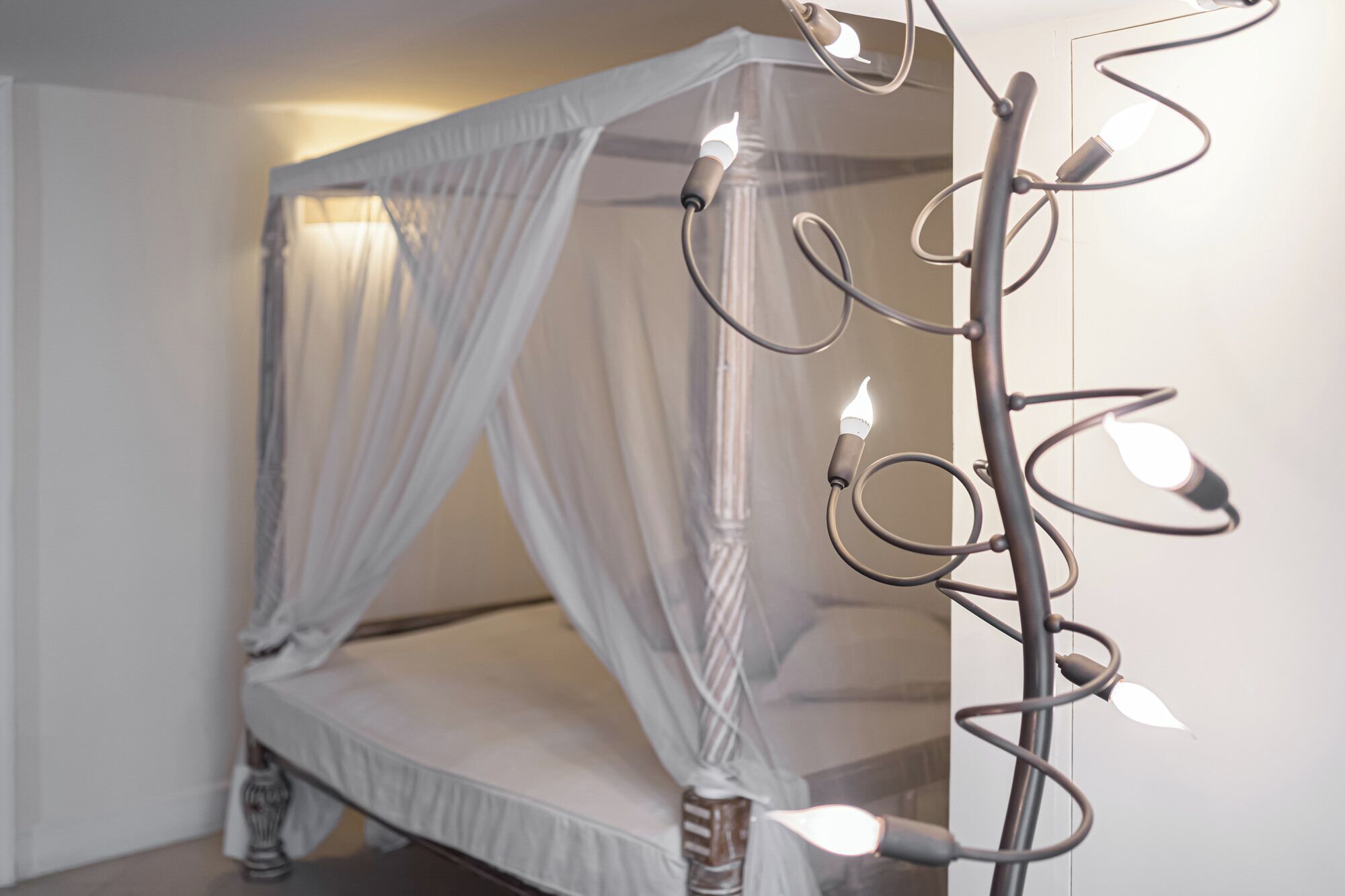 A bed with a canopy and a decorative metal structure with lights.