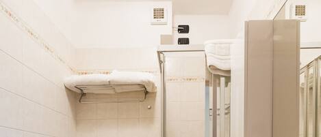 A bathroom with a toilet, bidet, sink, and shower.