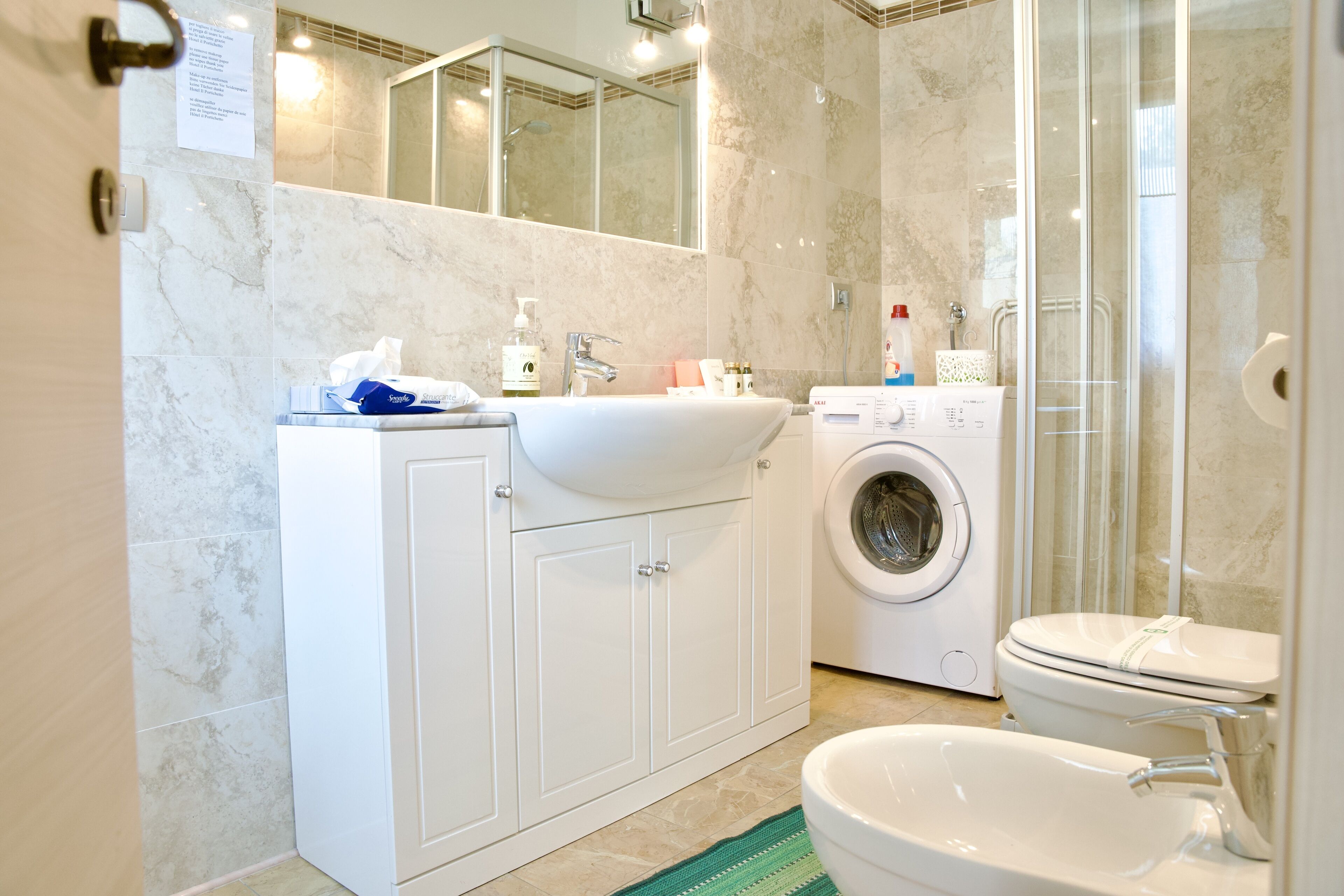 A modern bathroom with a sink, toilet, and washing machine.