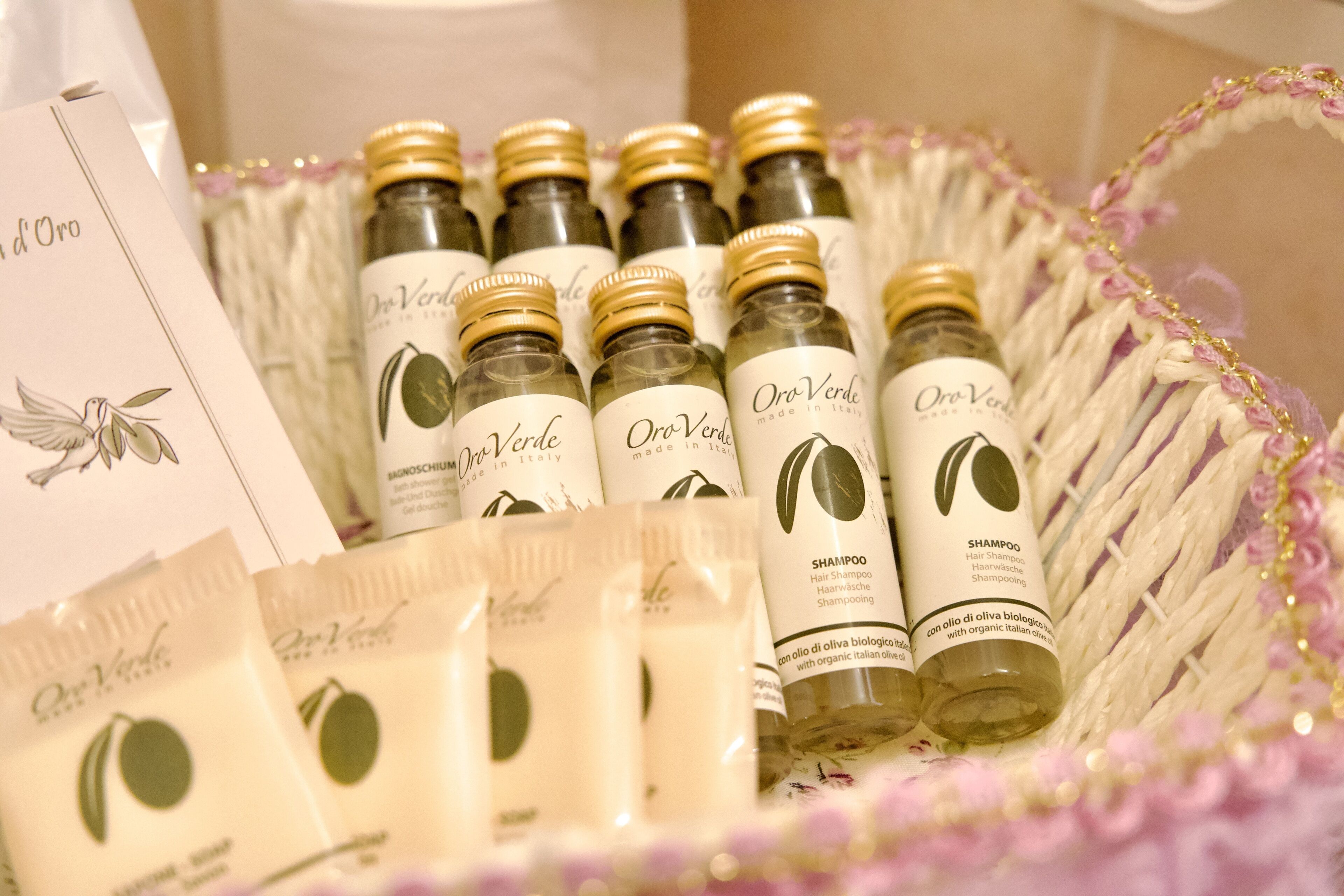 Un panier contenant des bouteilles de shampoing Oro Verde et des échantillons du même produit.