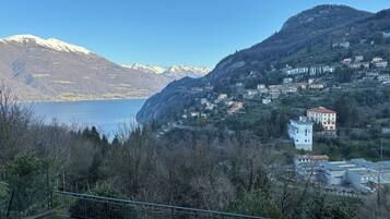 Paisatge montaños amb un llac, cases i un edifici amb panells solars.