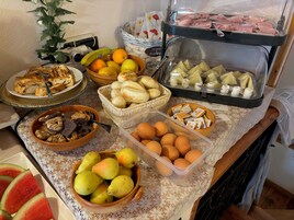 Ein Buffet mit verschiedenen Speisen, darunter Obst, Gebäck und Käse.