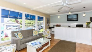 A modern living room with a sofa, coffee table, and a TV mounted on the wall. - Cape Colony Inn (Provincetown)