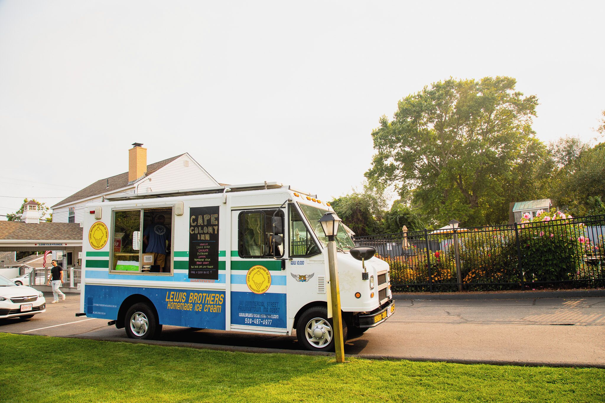 Un camion-restaurant aux couleurs bleu et blanc, arborant un logo et présentant une sélection de plats au menu.
