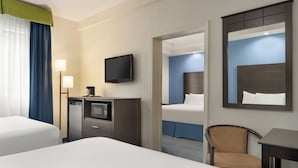 A hotel room with two beds, a desk with a television, a chair, and a mirror. - Days Inn by Wyndham Tamworth (Chocorua)
