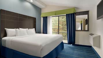 Habitación de hotel con una cama grande, una ventana con cortinas, un televisor de pantalla plana y un aire acondicionado de pared.