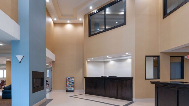 A spacious lobby with a reception desk, a fireplace, and a large window. - Days Inn by Wyndham Tamworth (Chocorua)