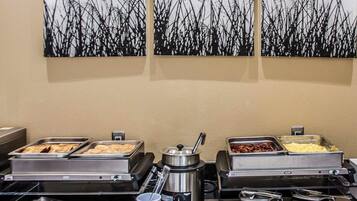 A buffet setup with various food items and a coffee machine.