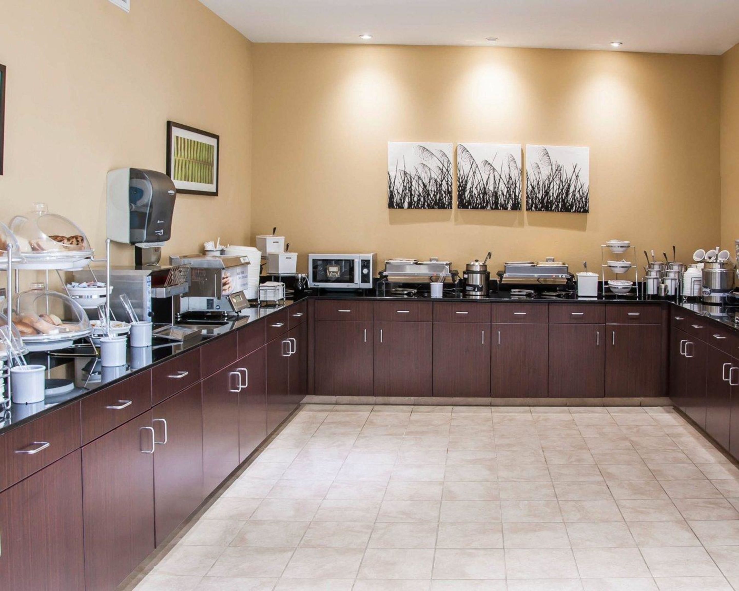 A modern kitchen with a large island, equipped with various appliances and a buffet setup.