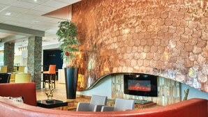 A lobby with a large fireplace, seating area, and a decorative wall. - KYRIAD PRESTIGE MULHOUSE - Basel (Sausheim)