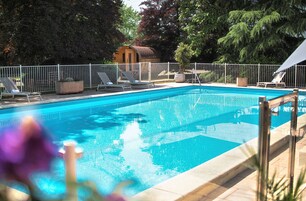Una piscina al aire libre de temporada, sombrillas