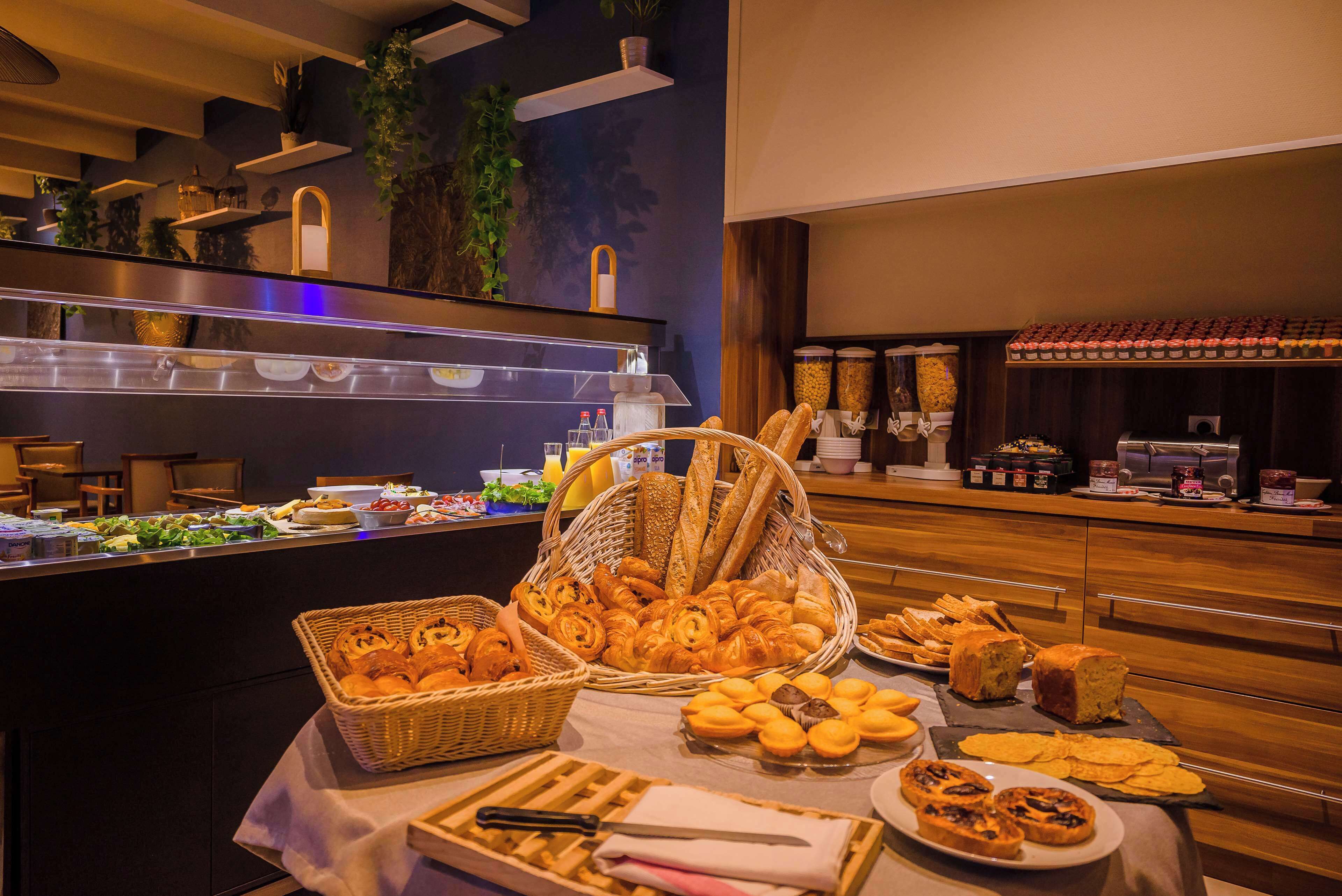 Un bufé con diversos panes, pasteles y un cuchillo sobre una mesa.