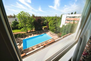 Una piscina al aire libre de temporada, sombrillas