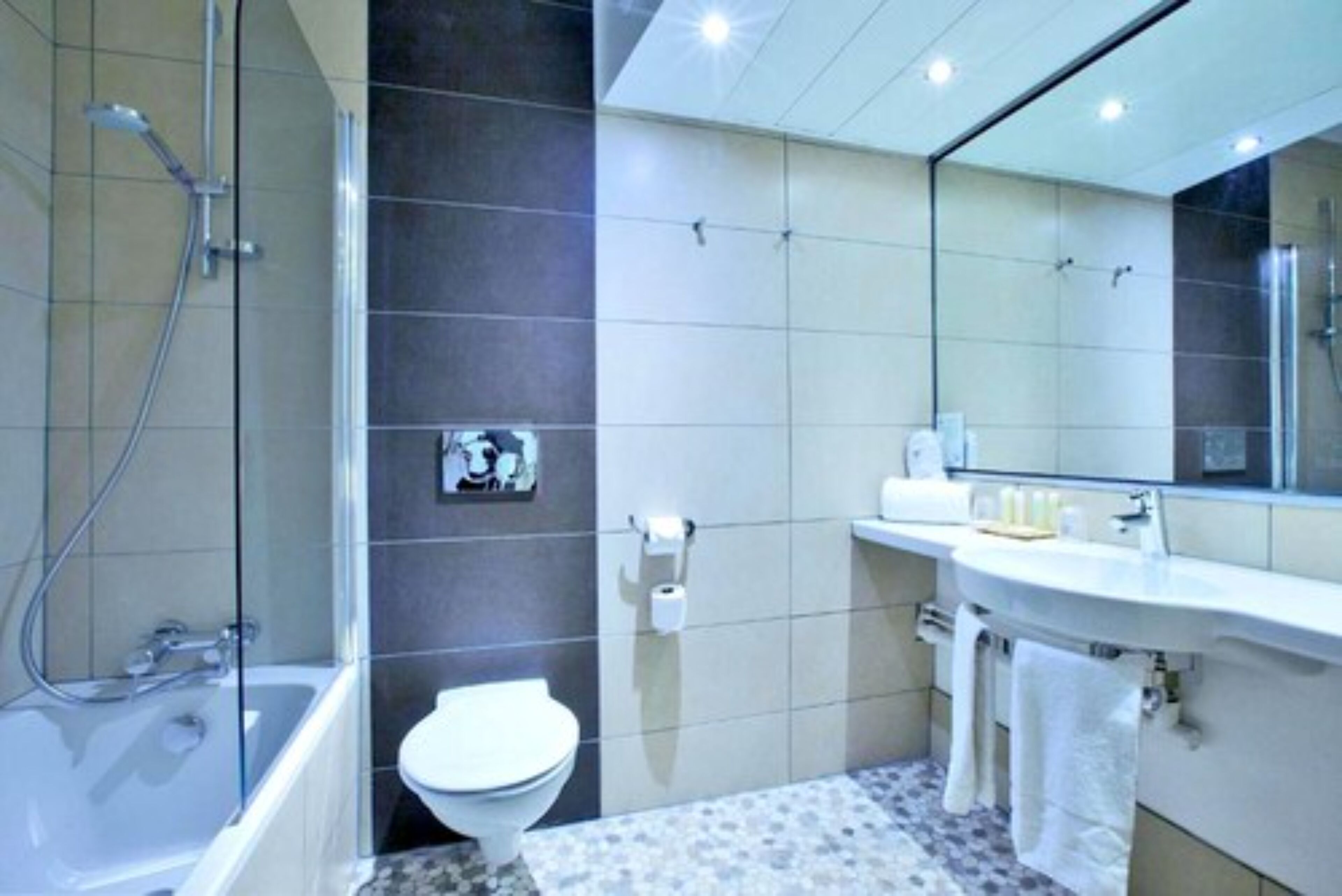 A modern bathroom with a bathtub, toilet, and sink.