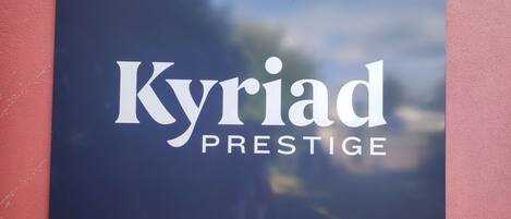 A sign with the text "Kyriad Prestige" on a dark background.