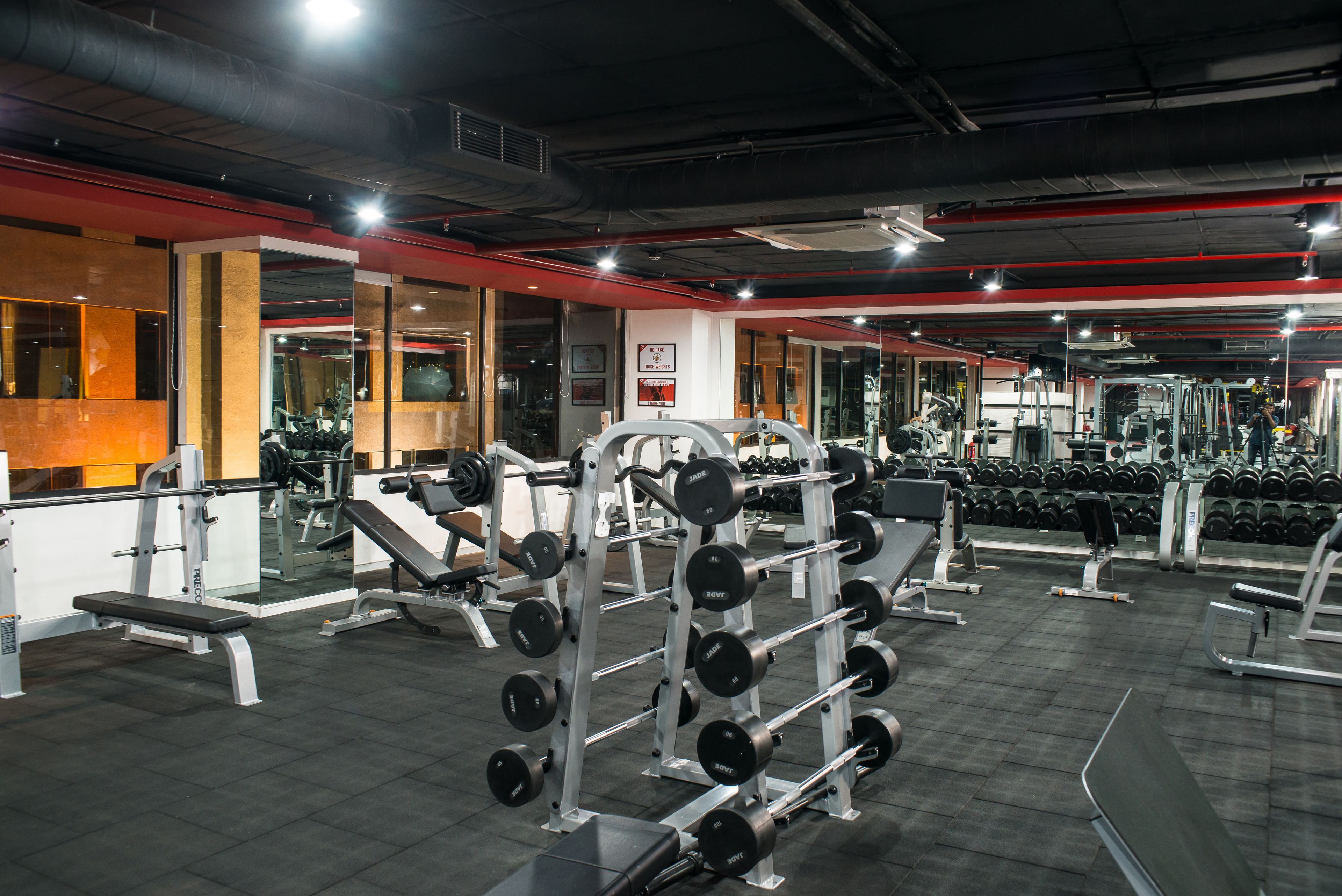 Ein Fitnessraum mit verschiedenen Gewichten, Bänken und Kurzhanteln.