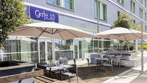 An outdoor seating area with tables and umbrellas at Gate 15 Restaurant.