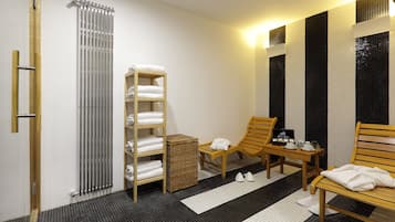 Relax in a serene spa room with a large radiator, wooden bench, and a small table.