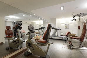 Une salle de sport équipée de machines de cardio, de matériel de musculation et dotée d’un mur avec des miroirs.