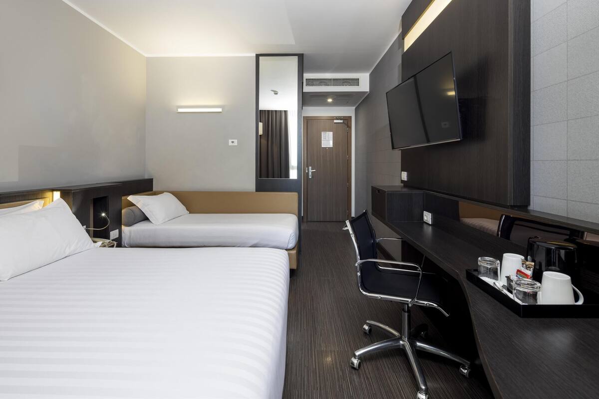 Hotelkamer met twee bedden, een bureau met stoel, een flatscreen televisie en een koffiehoek.